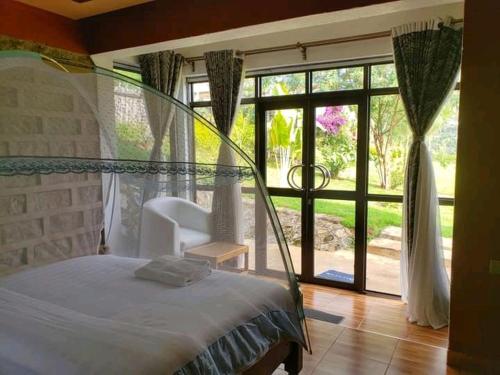 a bedroom with a bed and a large window at Sipi Valley Resort in Mbale