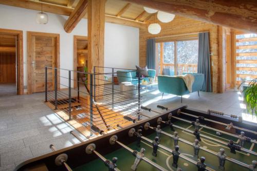 a living room with a pool table in front of a house at Chalet Argali - OVO Network in Le Grand-Bornand