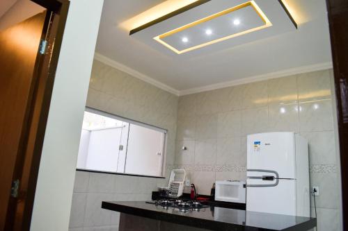 a kitchen with a white refrigerator and a counter at Casa Marilago in Camocim