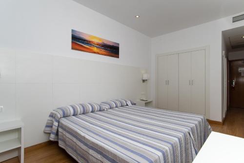 a bedroom with a bed and a painting on the wall at Hotel Voramar in Benidorm