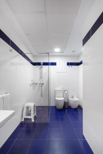 a bathroom with two toilets and a blue tile floor at Hotel Voramar in Benidorm