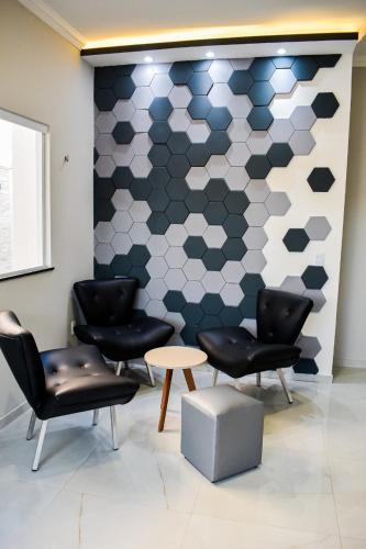 a waiting room with chairs and a geometric wall at Casa Marilago in Camocim
