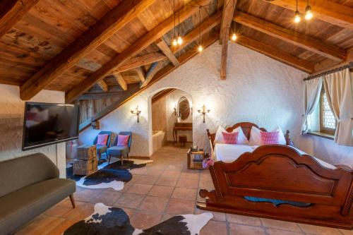 ein Schlafzimmer mit einem Bett und ein Wohnzimmer in der Unterkunft Swiss-Chalet Merlischachen - Historik Chalet-Hotel Lodge in Küssnacht