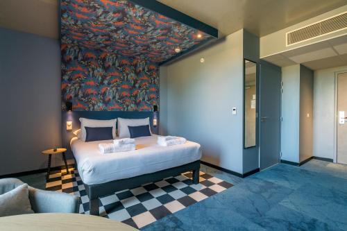 a bedroom with a bed with a painting on the wall at ibis Styles Dijon Sud Domaine De Beauregard 21600 Longvic in Longvic