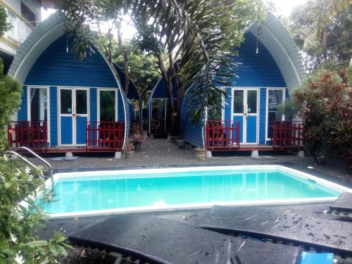 a swimming pool in front of a blue house at Airport Residence Inn in Katunayake