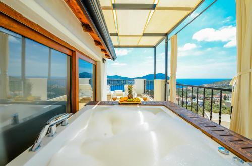 a bathtub in a room with a view of the ocean at Carla Apart Kalkan in Kalkan