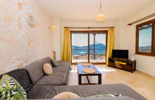 a living room with a couch and a tv at Carla Apart Kalkan in Kalkan