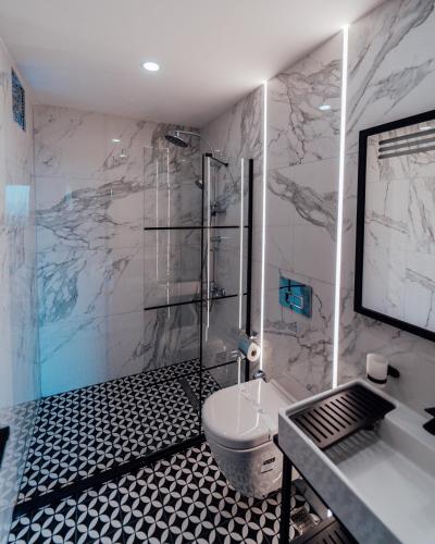 a bathroom with a shower and a toilet and a sink at Fortunella Suites in Finike