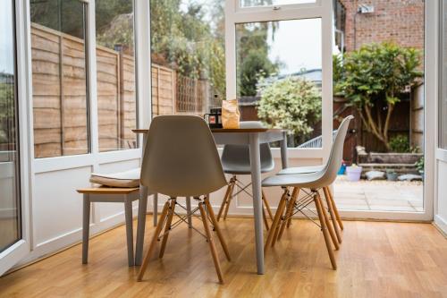 a table and chairs in a room with a window at Beautiful Town House with Private Garden and Patio in Canford Magna