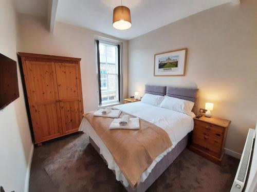 a bedroom with a large bed and a window at Malton Central Apartments in Malton