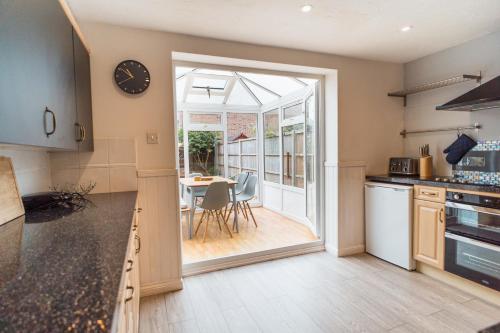 une cuisine avec une porte menant à une salle à manger dans l'établissement Beautiful Town House with Private Garden and Patio, à Canford Magna