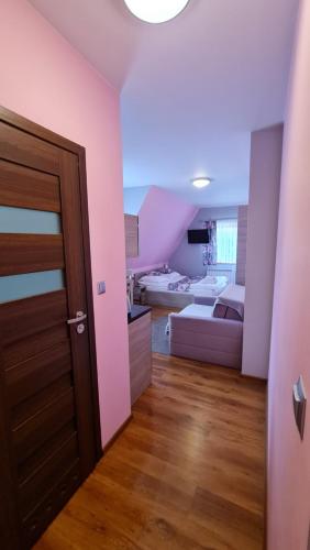 a room with a door and a bedroom with pink walls at Willa Świderka in Kościelisko