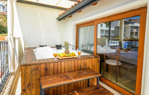 a wooden deck with a table on a balcony at Carla Apart Kalkan in Kalkan