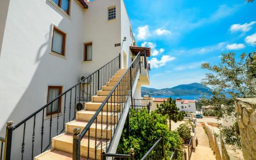 a staircase leading up to a building with a view of the ocean at Carla Apart Kalkan in Kalkan