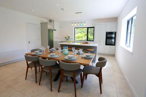 a kitchen and dining room with a wooden table and chairs at Luxury 6 Bedroom Spiddal Villa, Jacuzzi, Balcony in Galway