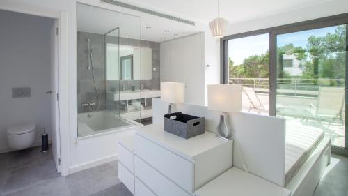 a white bathroom with a tub and a sink at VILLA MEXIC in Llafranc