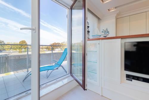 kuchnia z balkonem z niebieskim krzesłem w obiekcie Sailor Apartment Jastrzębia Góra by Renters Prestige w Jastrzębiej Górze
