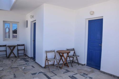 a room with chairs and a table and a blue door at Hotel Kastelakia Mykonos in Mýkonos City