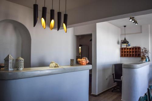 a kitchen with a counter and a dining room at Hotel Kastelakia Mykonos in Mýkonos City
