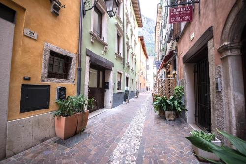 an alley with potted plants in an alley between buildings at 1Dest - Best Location in Riva del Garda