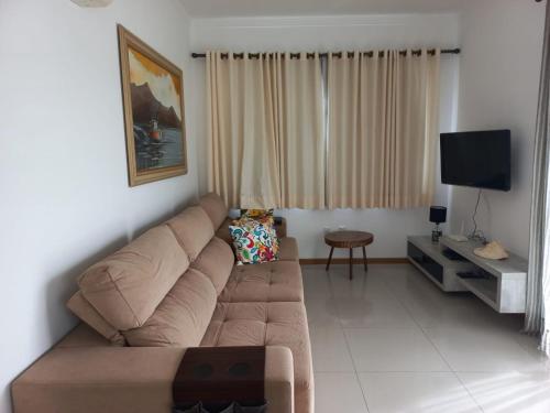 sala de estar con sofá y Tv LED en Viapiana Cobertura 301, en Bombinhas