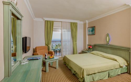 a hotel room with a bed and a balcony at Holiday Park Resort - Ultra All İnclusive in Okurcalar