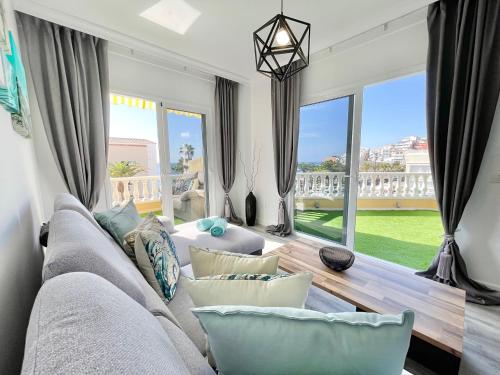 ein Wohnzimmer mit einem Sofa und einem großen Fenster in der Unterkunft PaulMarie Apartment Gigantes Ocean Lounge in Puerto de Santiago