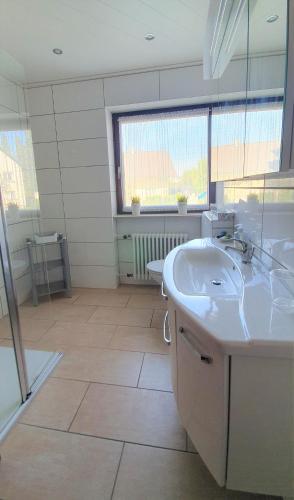 a bathroom with two sinks and a large window at Gästehaus Reinke - nahe Europa-Park in Ettenheim