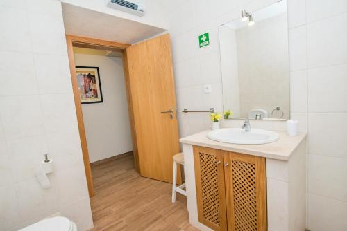 a bathroom with a sink and a mirror at Buganvília By Algartur in Tavira