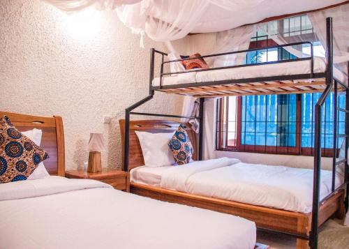 een slaapkamer met 2 stapelbedden en een raam bij Lost in Africa Arusha in Arusha