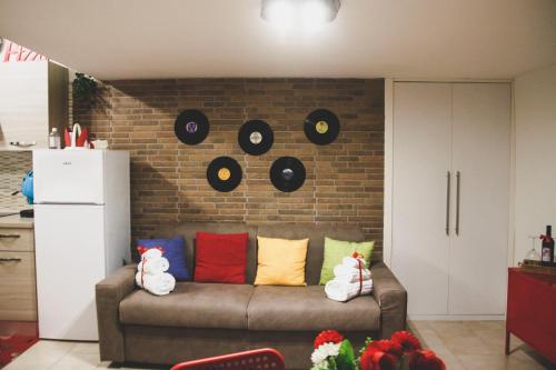 ein Wohnzimmer mit einem Sofa mit Platten an einer Backsteinwand in der Unterkunft Frizzi & Lazzi House in Neapel