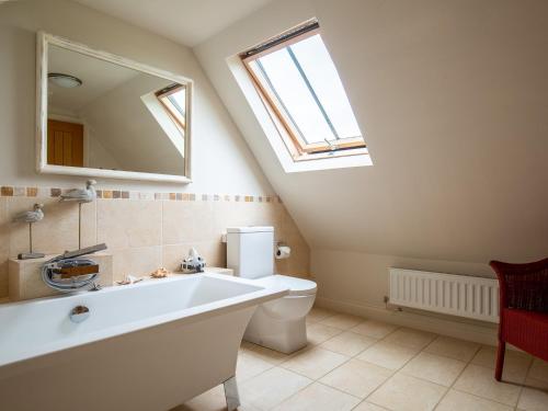 a bathroom with a tub and a toilet and a window at Swallows Rest in Broadway