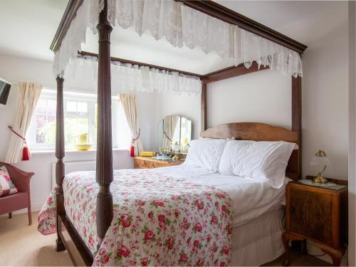 a bedroom with a four poster bed with a canopy at Swallows Rest in Broadway