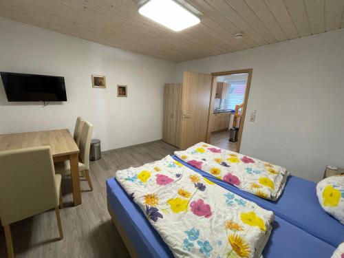 Habitación con cama, mesa y TV. en Haus 13 zum Südblick, en Garnbach