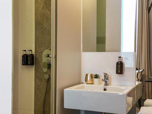 W łazience znajduje się biała umywalka i prysznic. w obiekcie ST Signature Bugis Beach, SHORT OVERNIGHT, 8 Hours, 11PM-7AM w Singapurze