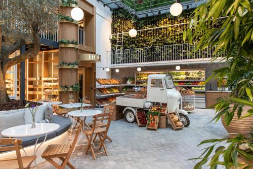 a store with tables and chairs and a truck in the middle at Ergon House Athens in Athens