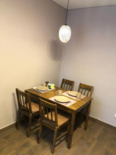 Квартира в центре города في أومان: طاولة طعام مع أربعة كراسي وضوء