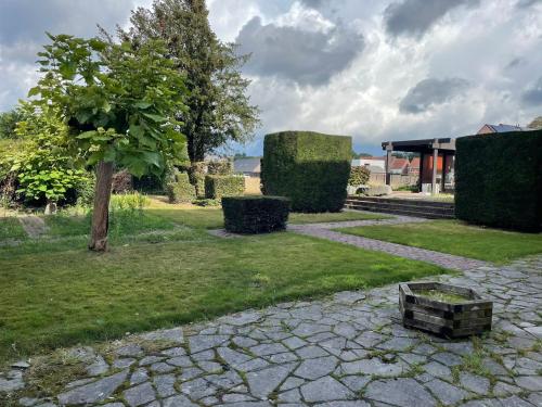einen Garten mit einem Baum und einem Steinweg in der Unterkunft B&B The White House in Wielsbeke