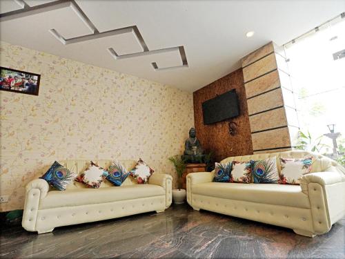 a living room with two white couches and a tv at Indira Nikunj Rubystone Exotic in Rishīkesh