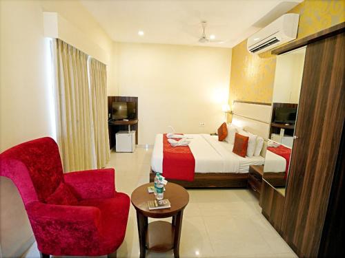 a hotel room with a bed and a chair at Indira Nikunj Rubystone Exotic in Rishīkesh