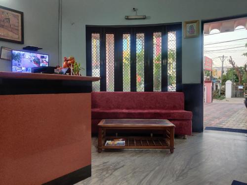 齋浦爾的住宿－Hotel Aarjee Crescent Jaipur，客厅配有红色沙发和茶几