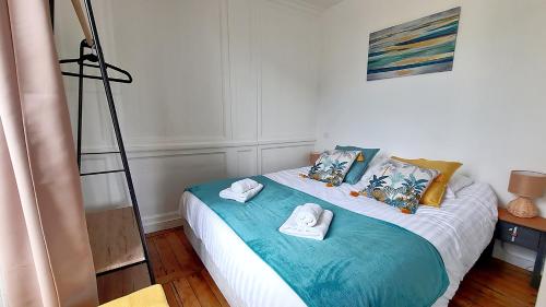 une chambre avec un lit avec des serviettes dessus dans l'établissement LES LICES, T2 de caractère en plein centre historique, à Vannes