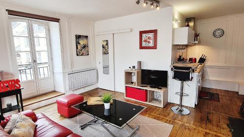 un salon avec un canapé et une télévision dans l'établissement LES LICES, T2 de caractère en plein centre historique, à Vannes