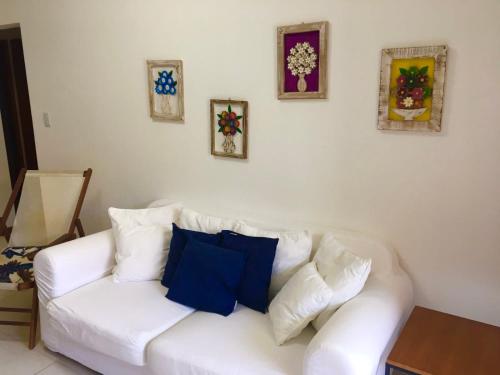 a white couch with blue pillows in a living room at Charming Guarajuba in Guarajuba