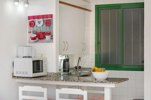 a kitchen with a counter with a microwave and a sink at Silent Flat in Puerto Rico de Gran Canaria