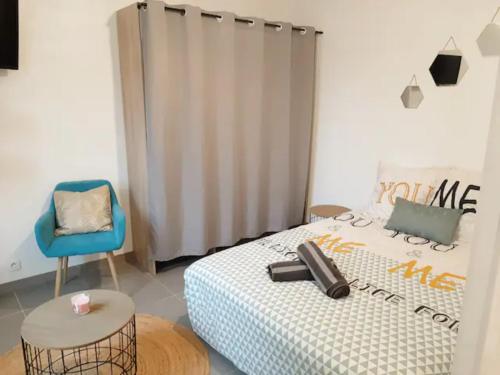 a bedroom with a bed and a blue chair at Le Petit Charmeur, parking, Wifi, gare in Flers
