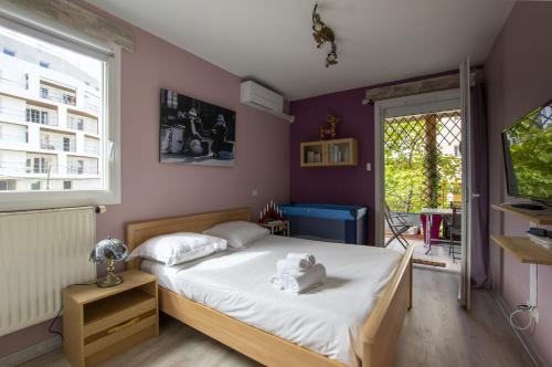 a bedroom with a bed with white sheets and a window at Port marianne - Première conciergerie in Montpellier