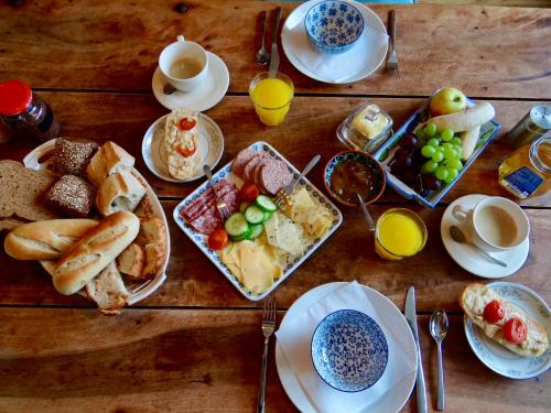 une table en bois surmontée d'assiettes de nourriture et de tasses de café dans l'établissement B&B de Pastory, à Warns
