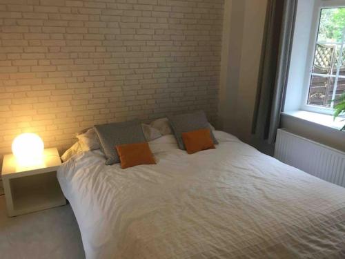 a white bed with two pillows and a brick wall at Chartleigh in Southampton