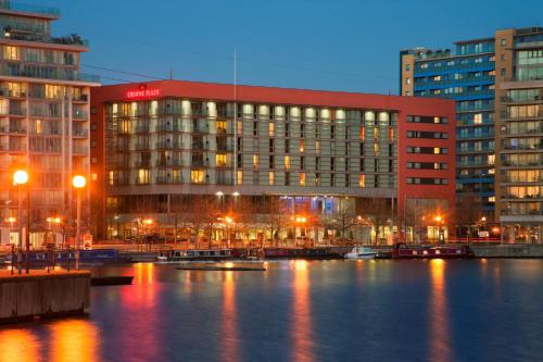 un edificio accanto a un corpo idrico con edifici di Crowne Plaza London - Docklands, an IHG Hotel a Londra